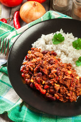 Hot chili con carne with ground beef, beans, tomatoes and corn served with rice