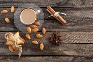  Coffee in a cup, biscuits and spices on a wooden surface 