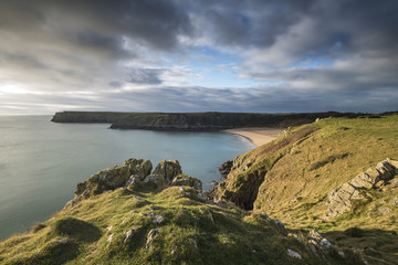 Stunning, vibrant sunrise landscape image of Barafundle Bay on Pembrokeshire Coast in Wales