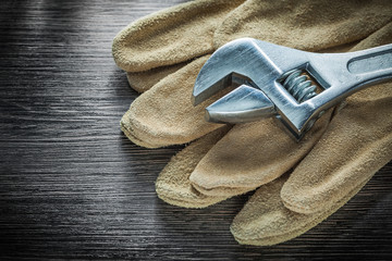 Adjustable spanner protective gloves on wooden board