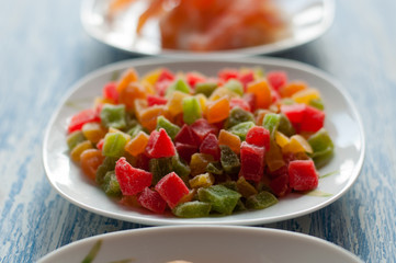 Candied pineapple in a white dish on a wooden background