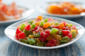 Candied pineapple cubes in a white dish on a wooden table