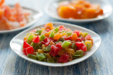 Candied pineapple cubes in a white dish on a wooden table