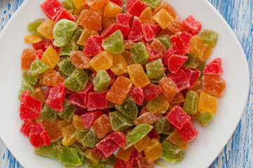 Candied papaya in a white dish on a wooden table