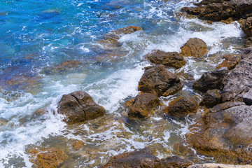 Rocky beach. Clear seawater. Small waves beating against the shore. Natural beautiful landscape.