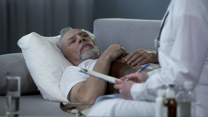 Adult man lying on couch and talking with doctor about health problems, disease
