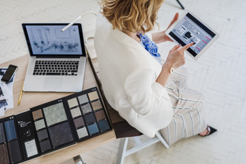 From above photo of elegant woman interior designer using tablet at her office.