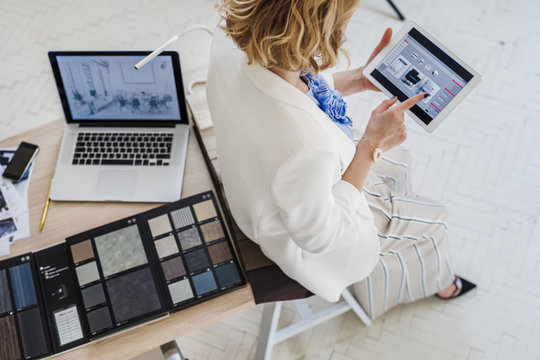 From above photo of elegant woman interior designer using tablet at her office.