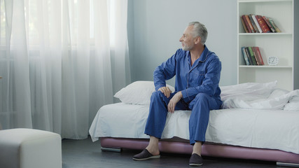 Obraz premium Optimistic senior man smiling after morning wakeup, enjoying happy life