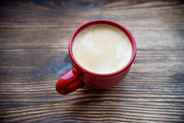 coffee in a red mug on an old wooden background