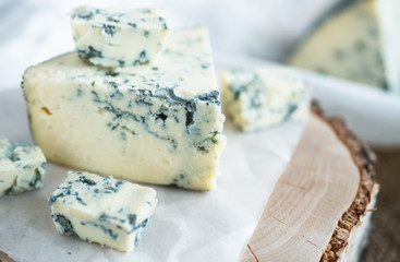 Blue cheese dorbly on parchment paper in the kitchen close up