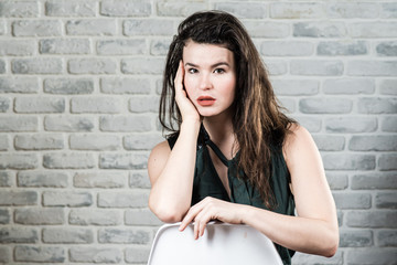 Portrait of a beautiful woman on the background of a light brick wall