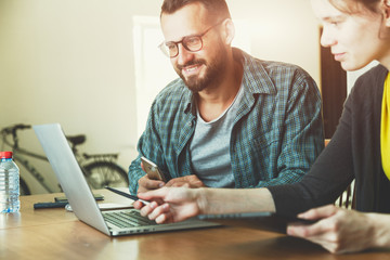 smiling man and woman working together with laptop