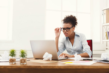 Angry business woman working on laptop at office