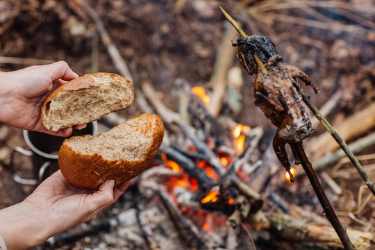 Hands of a hunter breaking and frying bread. bushcraft concept
