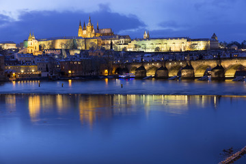 Fototapeta premium Christmas night snowy Prague Lesser Town with Charles Bridge and Prague Castle, Czech republic