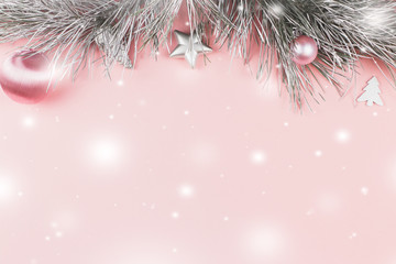 Christmas border with fir branches, christmas balls and silver ornaments on pastel pink background,...