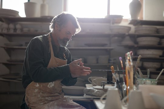 Male potter molding a clay