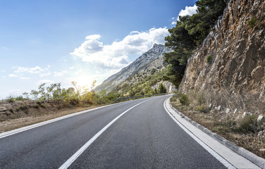 Country road through the rocky mountains and forest.