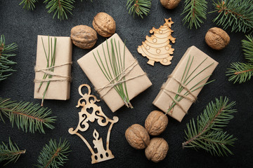 Three Christmas gift in vintage packing with nuts, decorations and a Christmas tree on a black background.