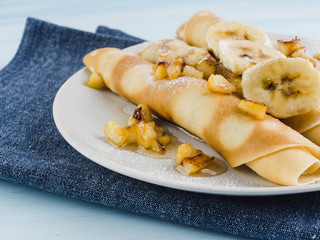 Delicious pancakes with banana, maple syrup and caramel apples