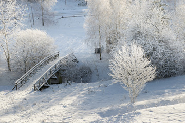Snowy, wooden bridge in a winter day. View from above.