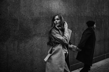 Naklejka premium Beautiful couple in stylish clothes in gray tones, city