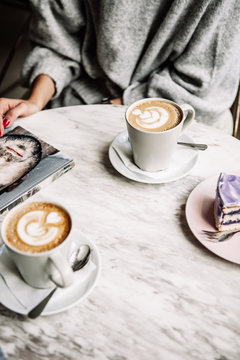 Female And Man Hands With Cups Of Coffee On The Background Of A Wooden Table