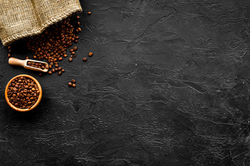 Fresh roasted coffee beans in bowl and scoop on black table top view copyspace - Powered by Adobe