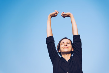 青空の下でリラックスをする女性