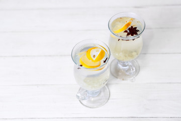 two cups of tea with ginger on a white wooden table