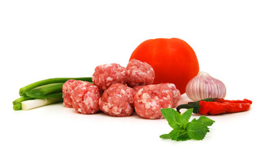 Raw meatballs with tomato, garlic, onion on white