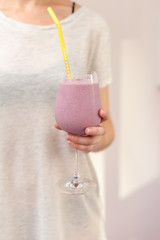 Woman holds a glass with pink cocktail