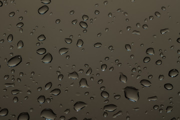 water drops on glass, a vivid image of rain drops on dark gray background, colorful background texture
