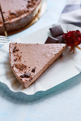 piece of Chocolate mousse cheesecake with a sprinkle of grated chocolate on a wooden table