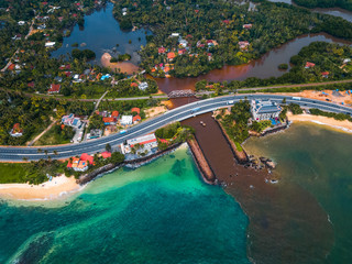 Aerial view of the dirty river flowing into the clear ocean. Sri Lanka