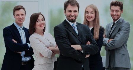 Smiling business team standing upright with their hands on their