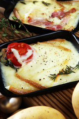 Delicious traditional Swiss melted raclette cheese on diced boiled or baked potato served in individual skillets.