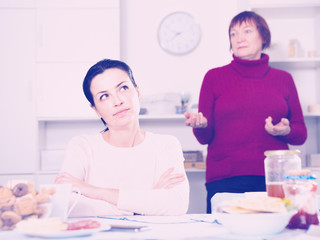 Mature female talking with young sad daughter
