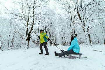 man pull woman on the sled