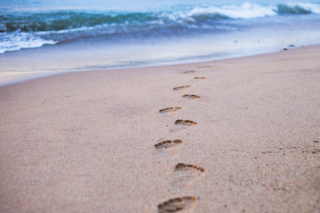 Human footprints on the sand beach. Travel vacations concept.