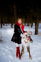 girl and reindeer in the winter forest
