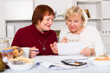 Two positive mature women with papers