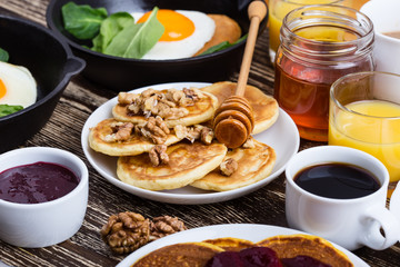 Valentine's day breakfast  with  heart shape fried egg in cast iron skillet and pancakes