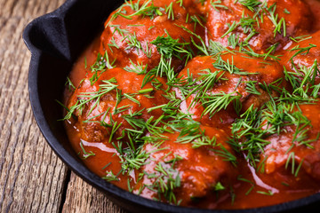 Beef meatballs in cast iron skillet on rustic wooden table