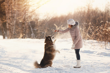Training of dogs. A girl is training her dog on street in winter