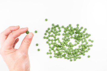 Young man hands holding a pills of chlorella, healthy