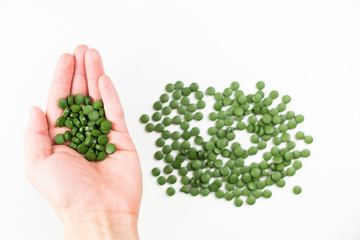 Young man hands holding a pills of chlorella, healthy