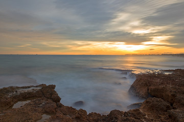 Obraz premium The calm sea in a very cloudy sunset