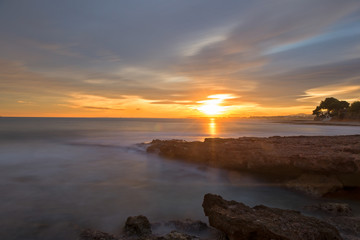 Obraz premium The calm sea in a very cloudy sunset